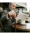 Homme dans un café parisien avec  sa canne de marche réglable. Un design original, masculin et pratique pour se balader.