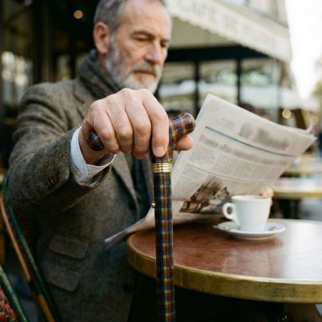 Homme dans un café parisien avec  sa canne de marche réglable. Un design original, masculin et pratique pour se balader.