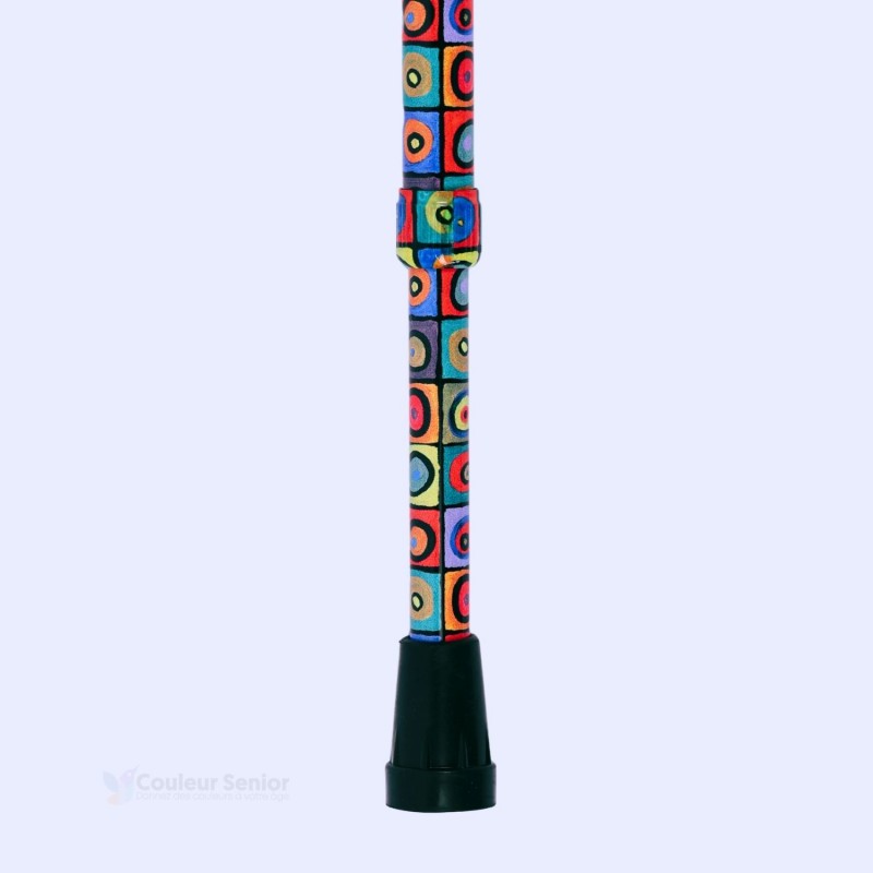 Détail de la base de la canne de marche motif Kandinsky carrés et cercles, montrant l'embout de sécurité en caoutchouc noir.